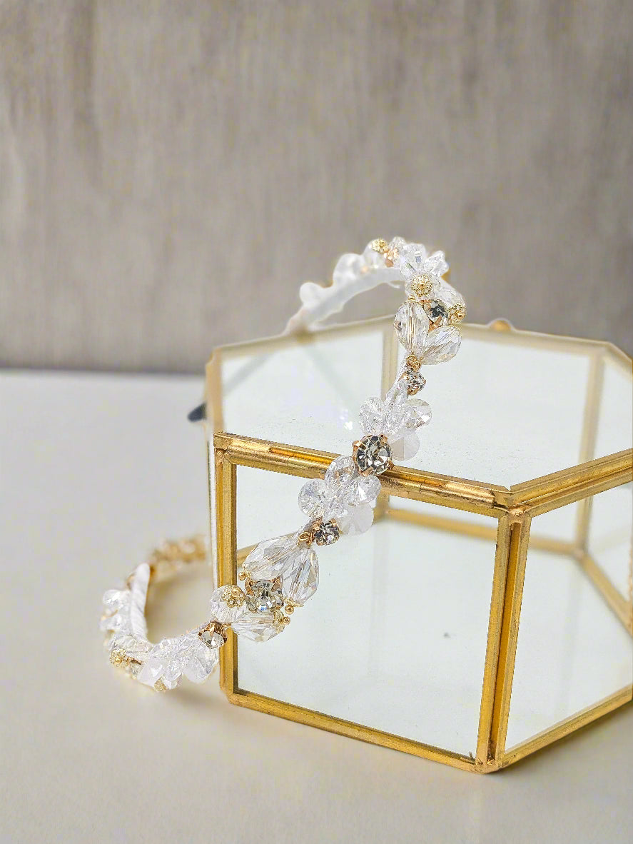 Beaded headband on a gold stand with a white background