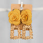 Gold coloured rectangular geometric drop earrings featuring a large yellow fabric flower