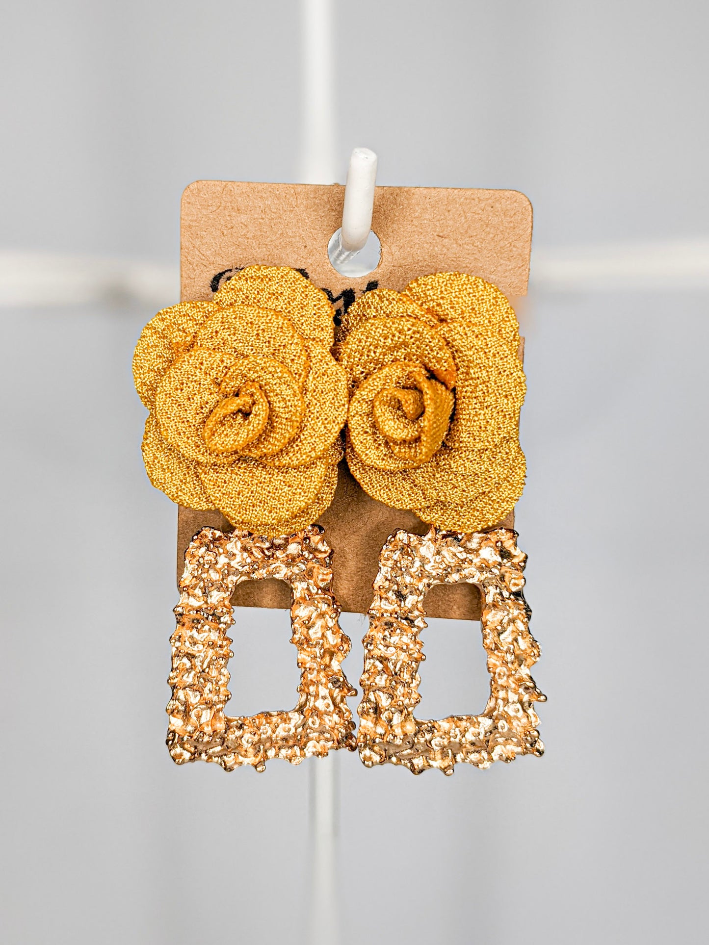 Gold coloured rectangular geometric drop earrings featuring a large yellow fabric flower