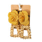 Gold coloured rectangular geometric drop earrings featuring a large yellow fabric flower